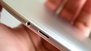 Close-up of sleek metallic device with brushed aluminum finish and precise edge detailing, held in hand showing premium build quality and weight